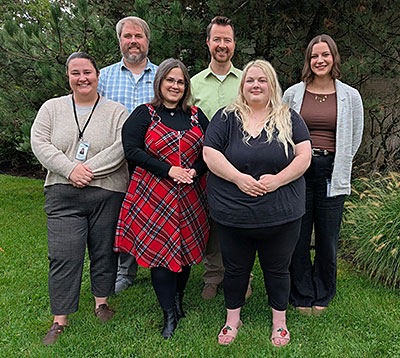 6 MaineStay employees with green tree in background